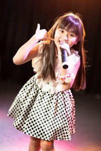 Yune singing wearing a polka-dot dress