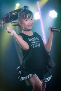 Yune dancing with the stage lights behind her