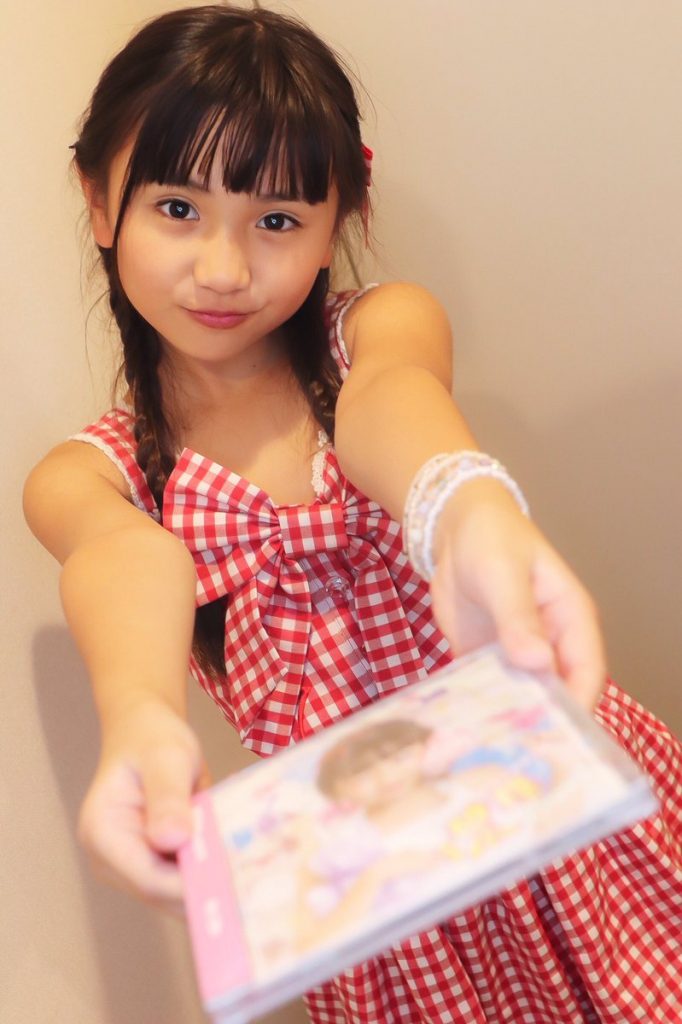 Yune offering a CD to the camera